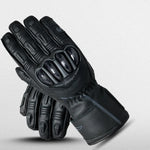RST Men's S1 waterproof Leather Black motorcycle gloves with reinforced knuckles and fingers, featuring sleek design and stitching, displayed against a light gray background.