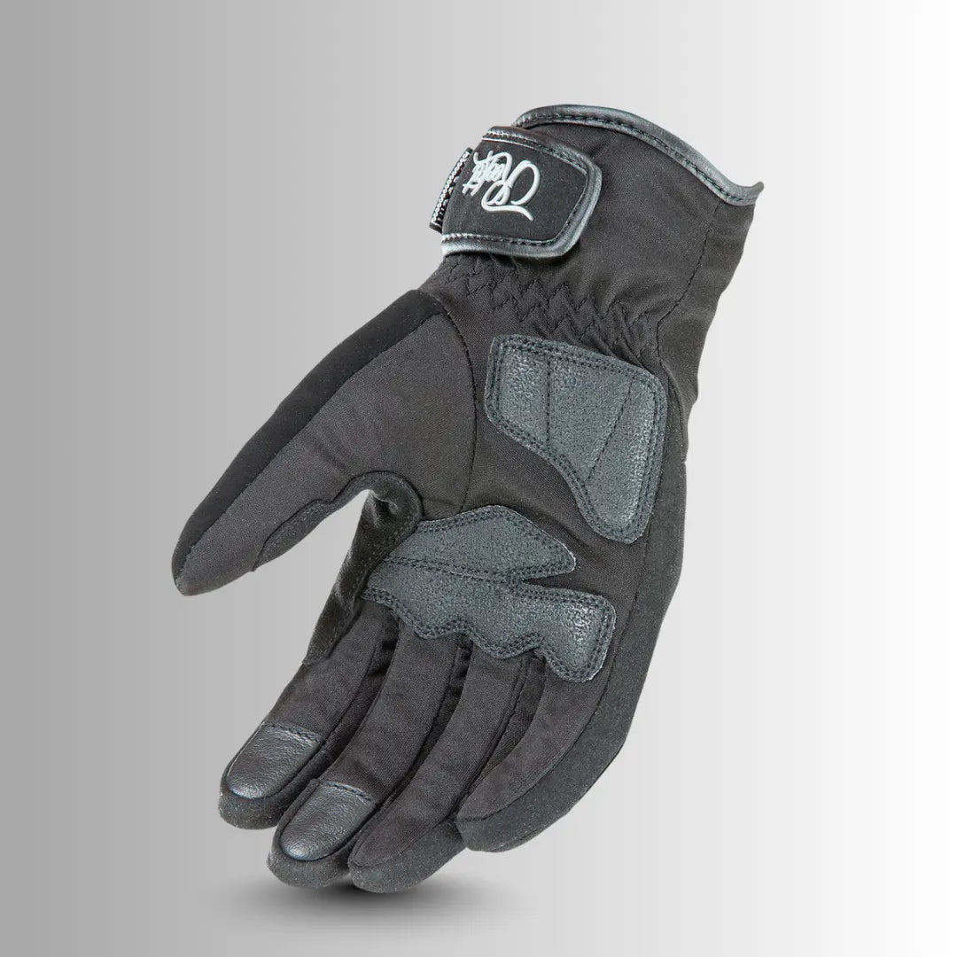 Close-up of Joe Rocket Ballistic Ultra Women's motorcycle glove showing molded knuckle armor, touchscreen-compatible fingertip, and slip-resistant padded palm.