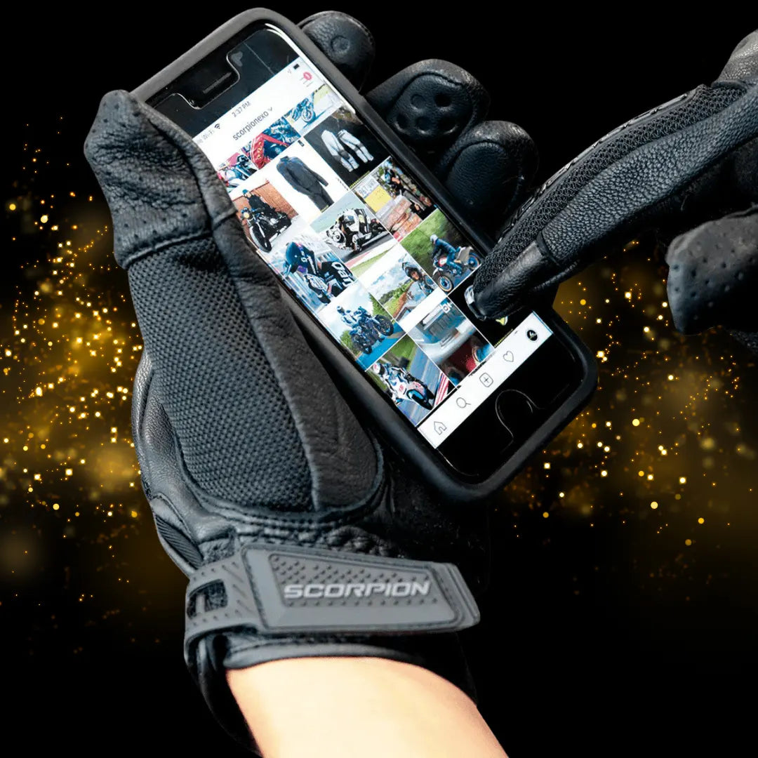 Scorpion Divergent motorcycle glove with touchscreen-ready index finger and thumb, used to operate a smartphone.