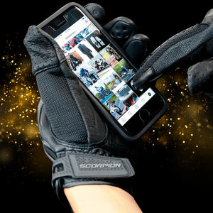 Scorpion Divergent motorcycle glove with touchscreen-ready index finger and thumb, used to operate a smartphone.