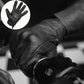 Close-up of black leather perforated motorcycle glove worn on hand, featuring touchscreen functionality for mobile use while riding